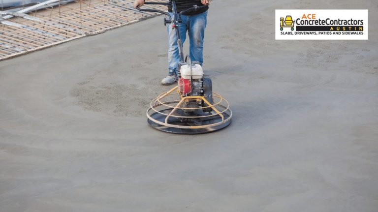 concrete contractor is smoothing out a concrete surface.