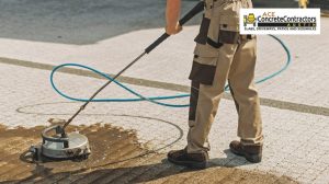 contractor using a power tool to clean the driveway