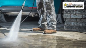contractor using a power washer to clean the driveway