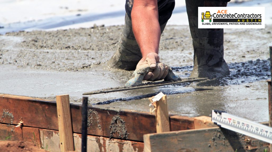 person smoothening wet concrete using trowel