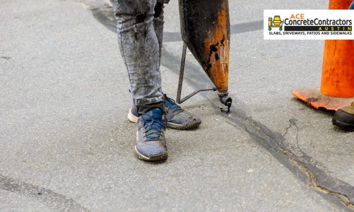 person pouring asphalt on concrete