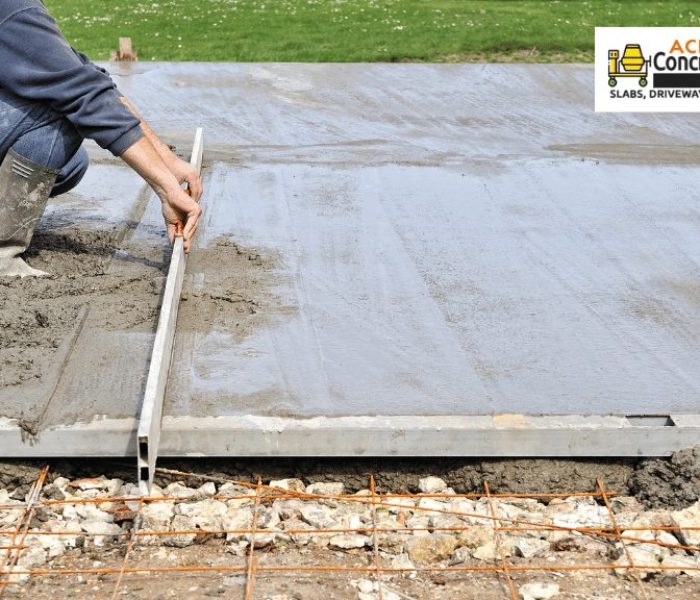 A concrete contractor is using a tool to flatten wet concrete