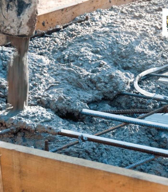 Contractor pouring a concrete mix to reinforced foundation